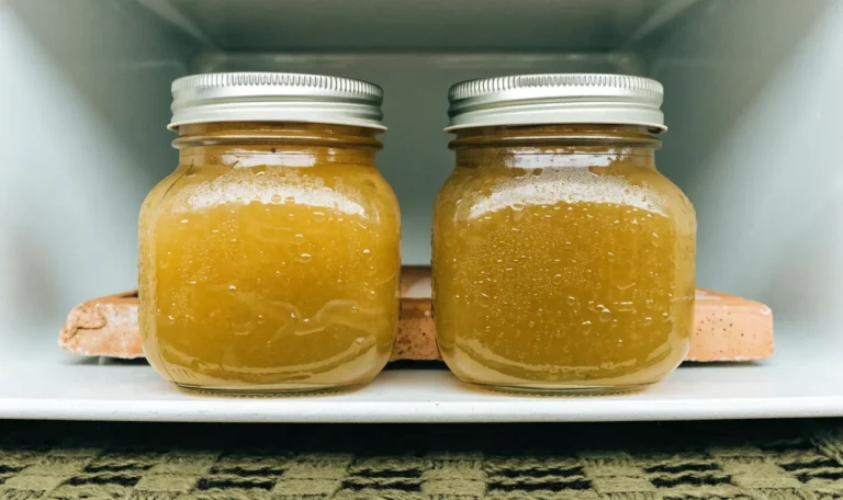 Two sealed glass mason jars of golden sea moss gel on a cool white refrigerator shelf, condensation on the glass, illustrating how long do sea moss last in the refrigerator.