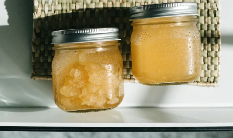 Two sealed glass mason jars of golden sea moss gel on a cool white refrigerator shelf, condensation on the glass, illustrating how long does sea moss gel last.