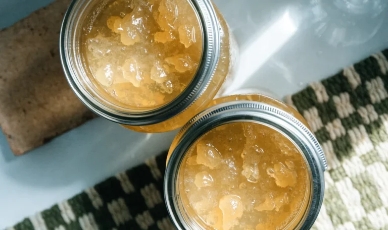 Two sealed glass mason jars of golden sea moss gel on a cool white refrigerator shelf, condensation on the glass, illustrating how long is sea moss good for in the fridge.