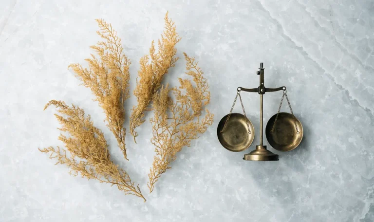 Dried gold sea moss arranged beside a small balance scale on pale stone