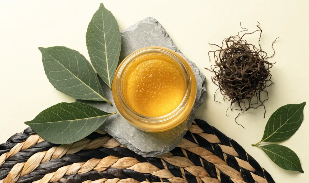 A still life of a glass jar of golden sea moss gel, a small pile of dried wildcrafted sea moss and fresh green leaves on a pale cream surface, illustrating sea moss taste.